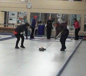 Frantically sweeping the ice to make the curling iron go faster!